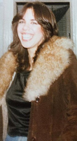 Woman in her late 20's wearing a coat.